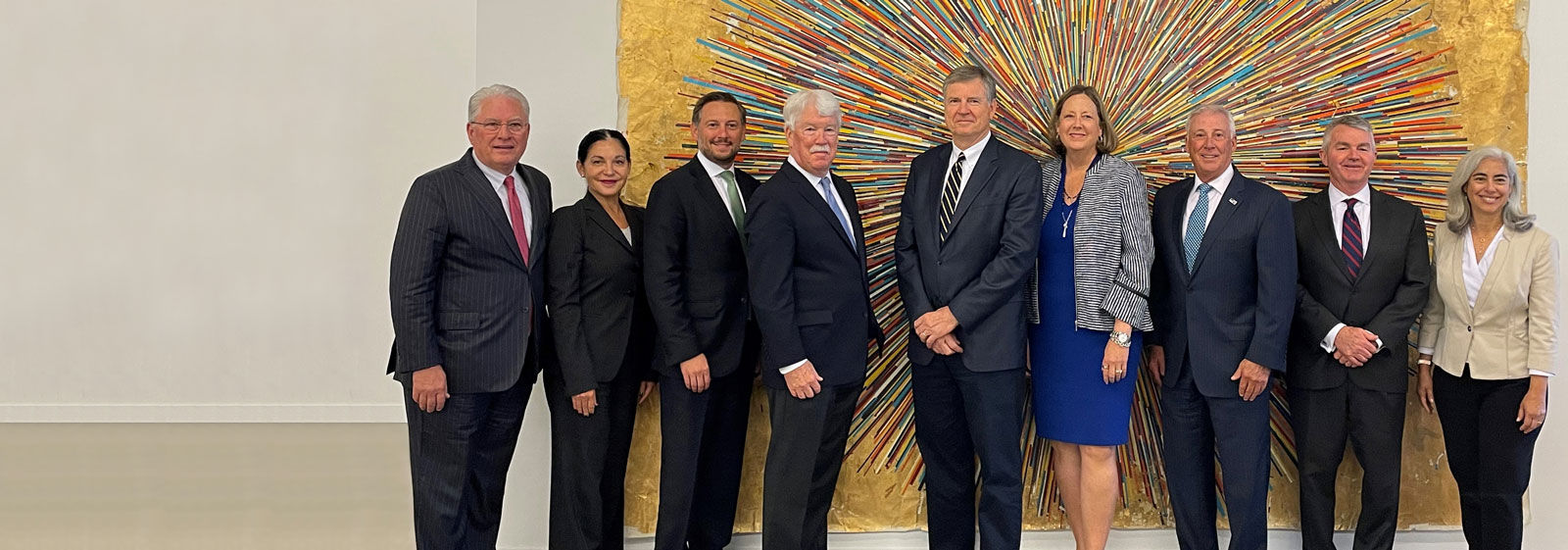 The Crestwood leadership team standing in front of a massive art piece